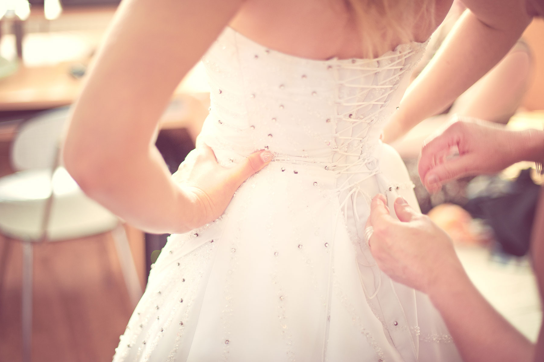 Девушка одевает свадебное платье